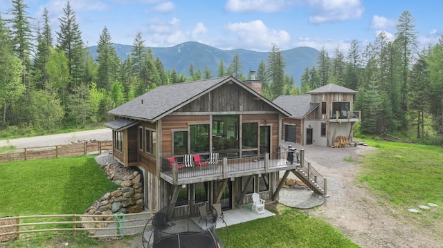 103 Glacier Hills Dr E, Martin City, MT 59926 - view of front facade with stairway, a patio, a deck with mountain view, a chimney, and a view of trees