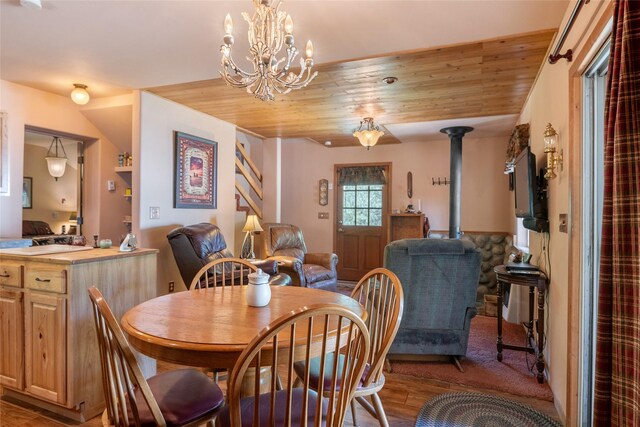18711 Copper Ridge Trl, Florence, MT 59833 - dining room with a wood stove, wood ceiling, wood finished floors, and a chandelier