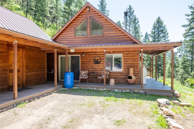 18711 Copper Ridge Trl, Florence, MT 59833 - back of property featuring metal roof, log veneer siding, and a deck