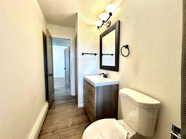 2513 8th Ave N, Great Falls, MT 59401 - half bath with a textured wall, wood finished floors, vanity, toilet, and baseboards
