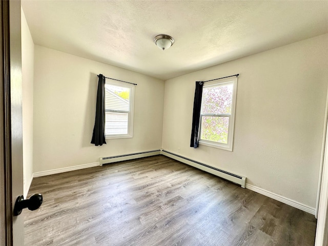 2513 8th Ave N, Great Falls, MT 59401 - spare room featuring wood finished floors, baseboards, a baseboard heating unit, and a textured ceiling