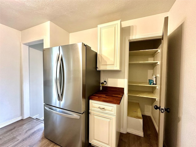 2513 8th Ave N, Great Falls, MT 59401 - kitchen featuring freestanding refrigerator, dark wood-style floors, wood counters, a textured ceiling, and baseboards