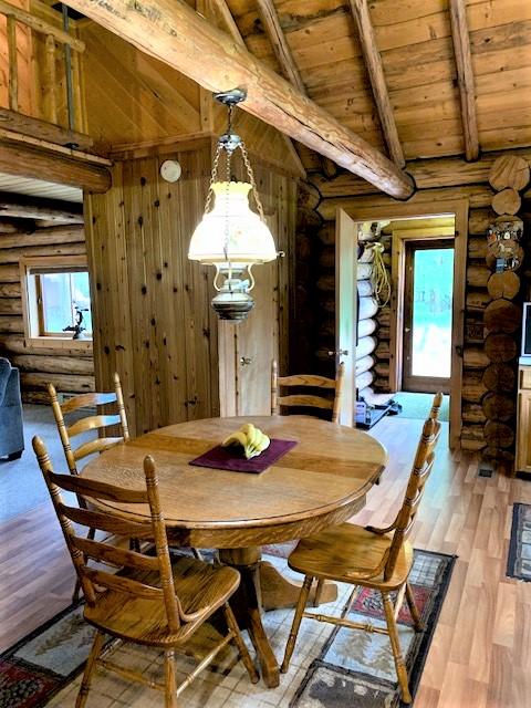 7191 Boy Scout Rd, Seeley Lake, MT 59868 - dining room with log walls, wood ceiling, and light wood-type flooring