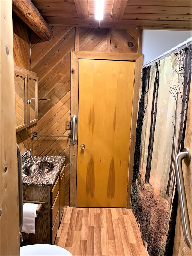 7191 Boy Scout Rd, Seeley Lake, MT 59868 - bathroom with wood ceiling, vanity, wood walls, wood finished floors, and toilet