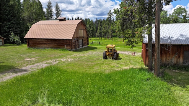 7191 Boy Scout Rd, Seeley Lake, MT 59868 - view of green lawn featuring a barn and an outbuilding