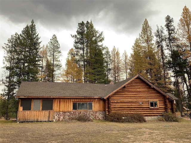 7191 Boy Scout Rd, Seeley Lake, MT 59868 - view of front facade featuring a shingled roof, log exterior, and stone siding