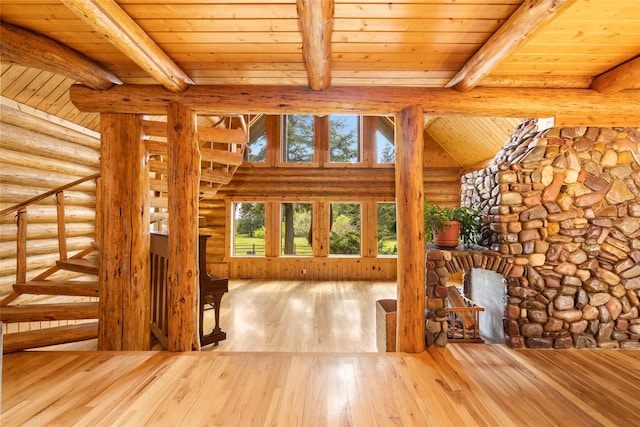 1473 Foothill Rd, Kalispell, MT 59901 - unfurnished living room featuring log walls, hardwood / wood-style flooring, wooden ceiling, and stairway