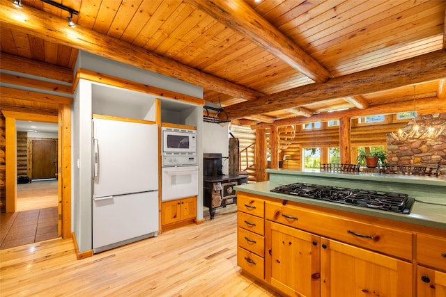 1473 Foothill Rd, Kalispell, MT 59901 - kitchen featuring white appliances, rustic walls, a wood stove, light wood-style flooring, and a wood ceiling with exposed beams