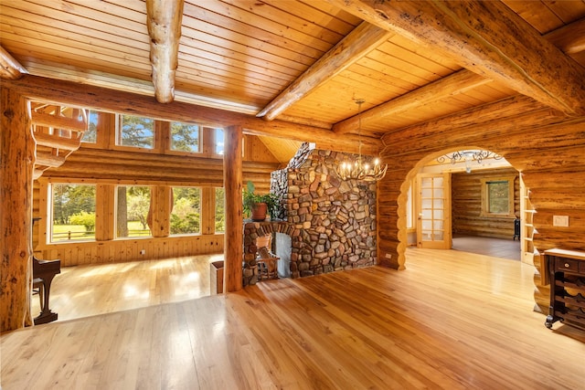 1473 Foothill Rd, Kalispell, MT 59901 - unfurnished living room featuring arched walkways, hardwood / wood-style floors, rustic walls, a wood ceiling with exposed beams, and a chandelier