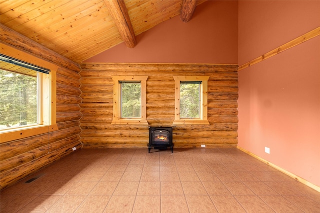 1473 Foothill Rd, Kalispell, MT 59901 - empty room with log walls, a wood stove, healthy amount of natural light, a wooden ceiling with exposed beams, and high vaulted ceiling