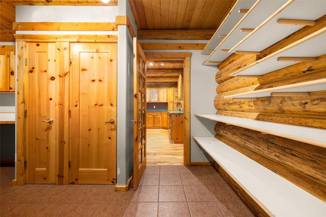 1473 Foothill Rd, Kalispell, MT 59901 - hall featuring a wood ceiling with exposed beams, log walls, and tile patterned floors