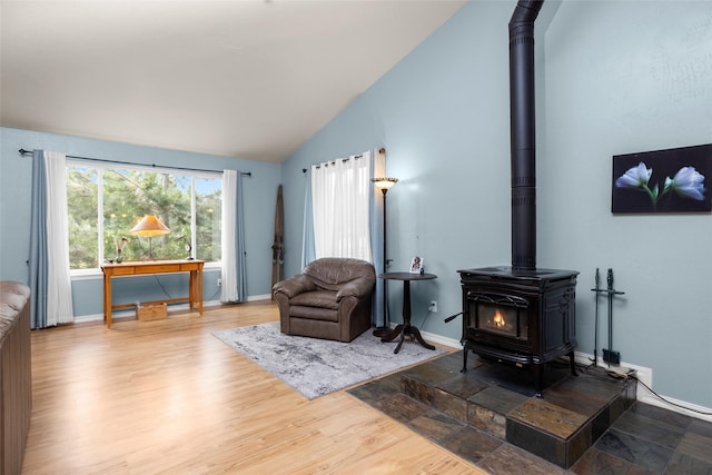 1473 Foothill Rd, Kalispell, MT 59901 - living area featuring a wood stove, wood finished floors, and high vaulted ceiling