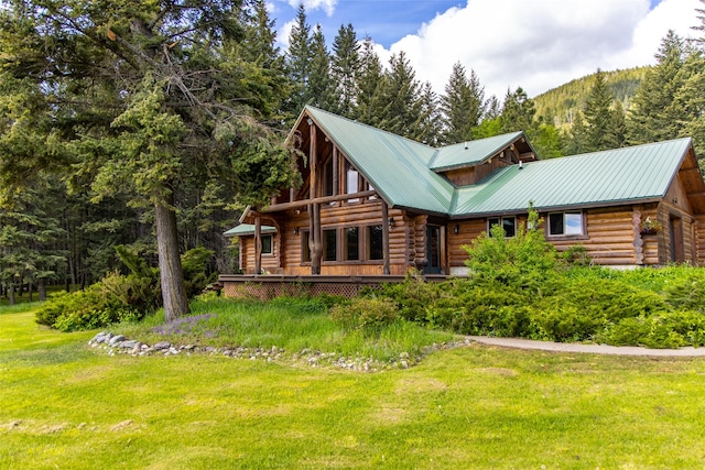 1473 Foothill Rd, Kalispell, MT 59901 - view of front of home with log siding, a front yard, and a metal roof