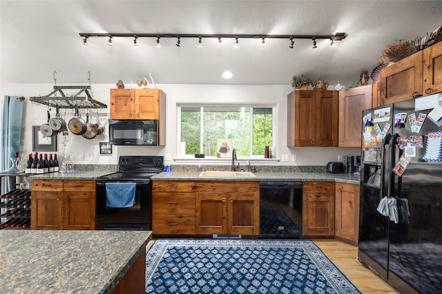 1473 Foothill Rd, Kalispell, MT 59901 - kitchen with black appliances, rail lighting, light wood-type flooring, and brown cabinets