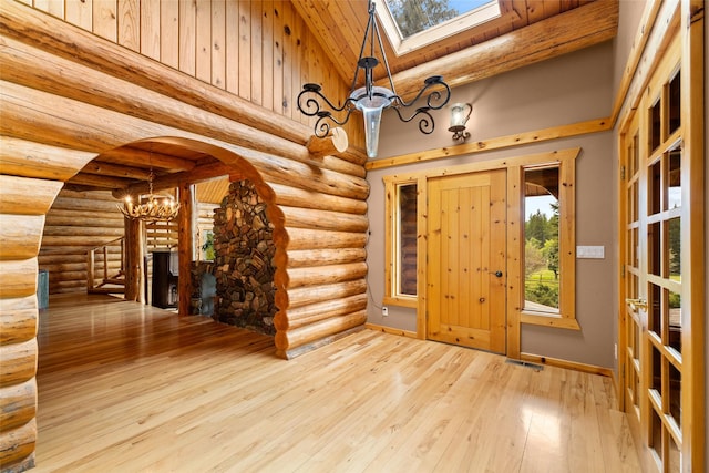1473 Foothill Rd, Kalispell, MT 59901 - entryway featuring a chandelier, a skylight, rustic walls, wooden ceiling, and hardwood / wood-style floors