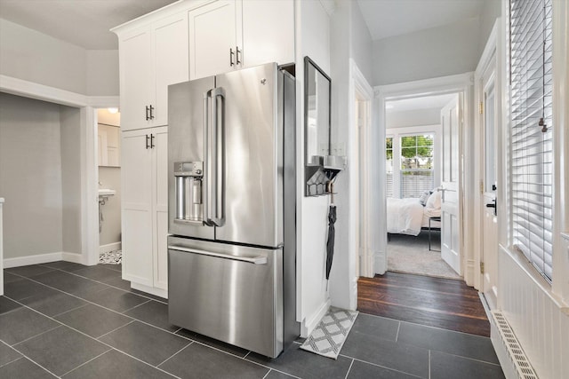 322 W Lawrence St, Helena, MT 59601 - kitchen featuring stainless steel refrigerator with ice dispenser, baseboard heating, dark tile patterned floors, white cabinetry, and baseboards