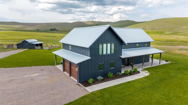 42730 Ridgeway Rd, Charlo, MT 59824 - view of front of home with board and batten siding, an attached garage, a front yard, and driveway