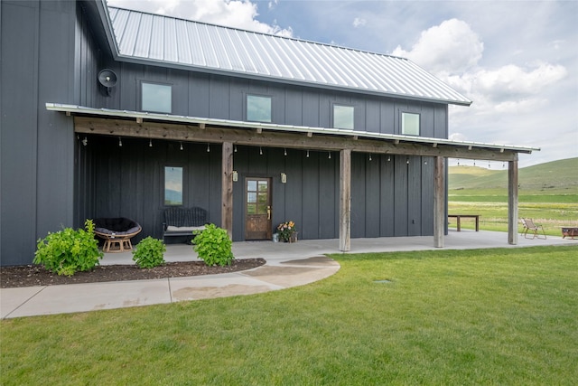 42730 Ridgeway Rd, Charlo, MT 59824 - rear view of house featuring board and batten siding, a yard, a patio area, and metal roof