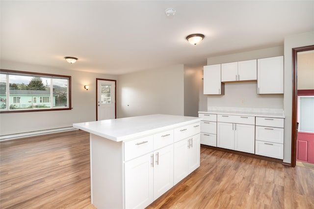 413 S Oak St, Townsend, MT 59644 - kitchen with light countertops, baseboard heating, white cabinets, and light wood-type flooring