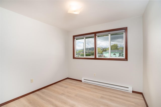 413 S Oak St, Townsend, MT 59644 - empty room with a baseboard radiator, light wood-type flooring, and baseboards