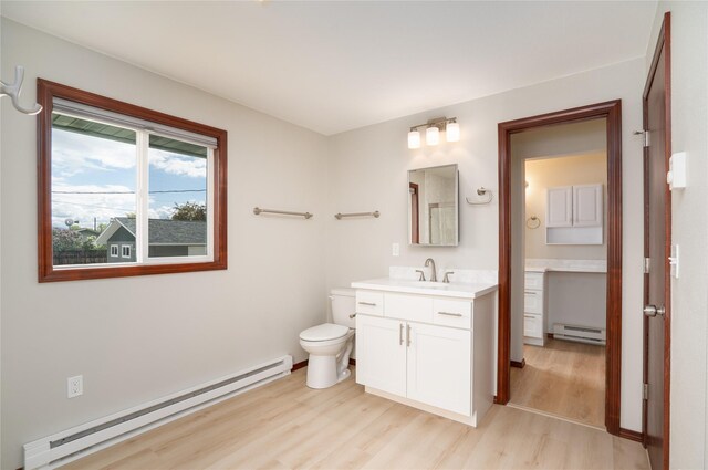 413 S Oak St, Townsend, MT 59644 - bathroom with a baseboard radiator, wood finished floors, vanity, and toilet
