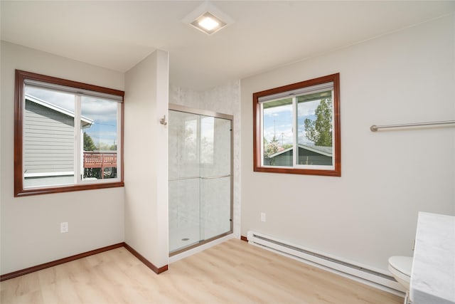 413 S Oak St, Townsend, MT 59644 - full bathroom with baseboard heating, wood finished floors, a shower stall, toilet, and baseboards