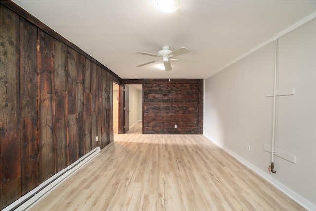 413 S Oak St, Townsend, MT 59644 - spare room with a baseboard radiator, a ceiling fan, wood finished floors, baseboards, and wooden walls
