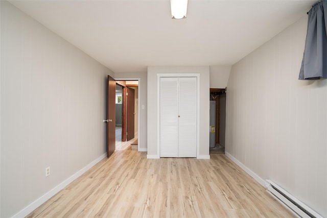 413 S Oak St, Townsend, MT 59644 - unfurnished bedroom with a baseboard heating unit, light wood finished floors, a closet, and water heater