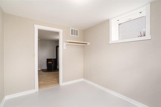 413 S Oak St, Townsend, MT 59644 - unfurnished bedroom featuring a wood stove and baseboards