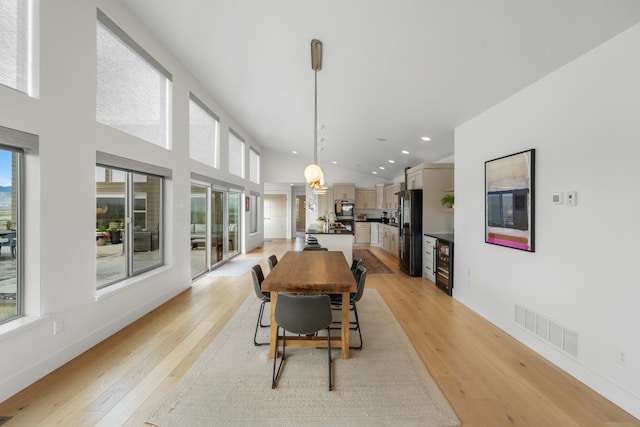 4910 Lauryn Ct, Helena, MT 59602 - dining space with beverage cooler, light wood finished floors, recessed lighting, baseboards, and high vaulted ceiling