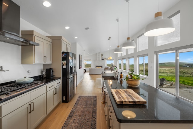 4910 Lauryn Ct, Helena, MT 59602 - kitchen featuring fridge with ice dispenser, exhaust hood, a large island, stainless steel gas cooktop, and plenty of natural light