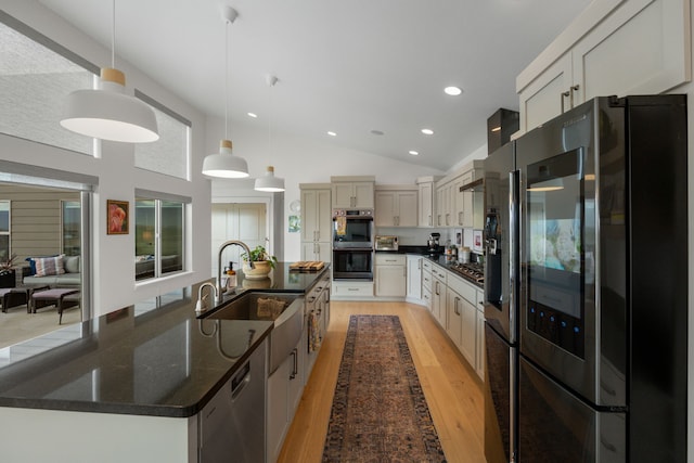 4910 Lauryn Ct, Helena, MT 59602 - kitchen featuring stainless steel appliances, a sink, light wood-style floors, hanging light fixtures, and a large island with sink