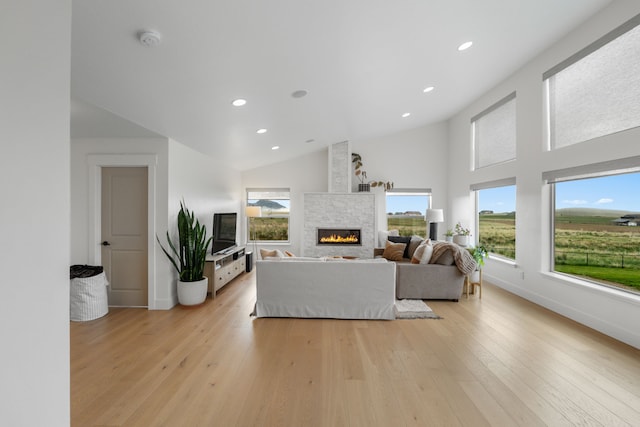 4910 Lauryn Ct, Helena, MT 59602 - living room featuring a stone fireplace, light wood finished floors, recessed lighting, high vaulted ceiling, and baseboards