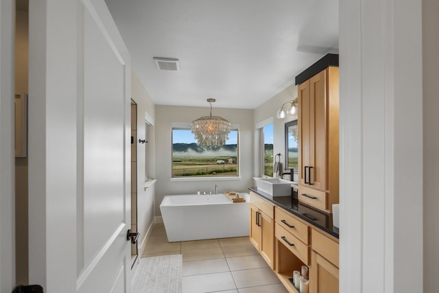 4910 Lauryn Ct, Helena, MT 59602 - bathroom with vanity, a freestanding tub, a chandelier, and tile patterned flooring