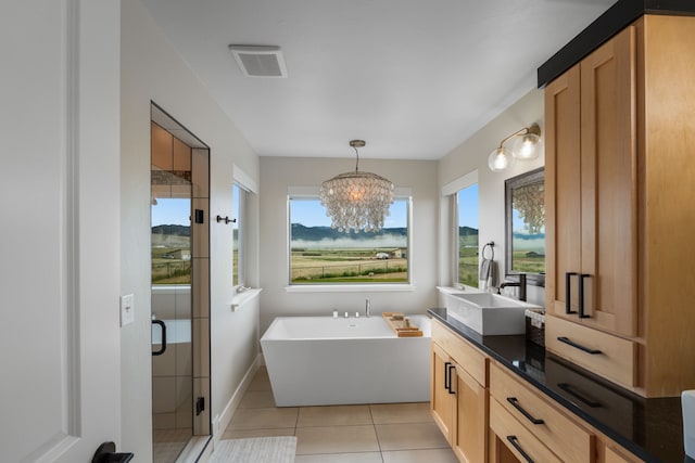 4910 Lauryn Ct, Helena, MT 59602 - bathroom featuring vanity, a soaking tub, a shower stall, a chandelier, and tile patterned floors