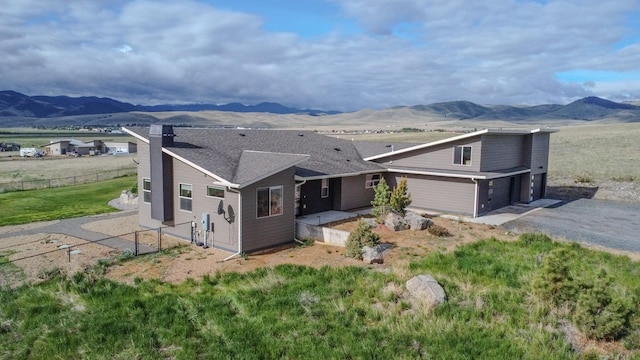 4910 Lauryn Ct, Helena, MT 59602 - exterior space featuring a mountain view, a chimney, an attached garage, and driveway