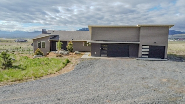 4910 Lauryn Ct, Helena, MT 59602 - modern home featuring dirt driveway, a mountain view, and a chimney