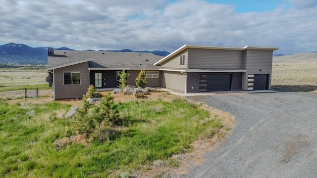 4910 Lauryn Ct, Helena, MT 59602 - modern home with a chimney, gravel driveway, and a mountain view