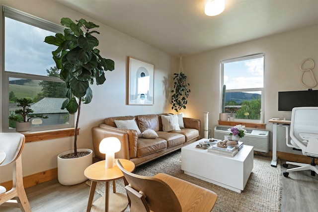 1245 Waverly St Unit 301, Missoula, MT 59802 - living room with wood finished floors, a wall unit AC, an office area, and baseboards