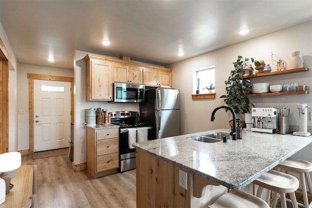 1245 Waverly St Unit 301, Missoula, MT 59802 - kitchen with stainless steel appliances, a sink, light brown cabinets, a peninsula, and light wood-style flooring