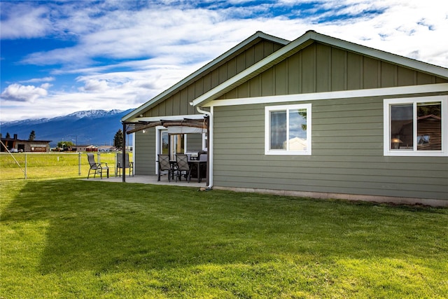 435 6th Ave NW, Ronan, MT 59864 - back of property featuring board and batten siding, a mountain view, and a patio area