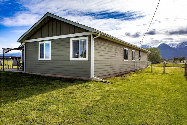 435 6th Ave NW, Ronan, MT 59864 - view of property exterior with board and batten siding, a mountain view, and a gate