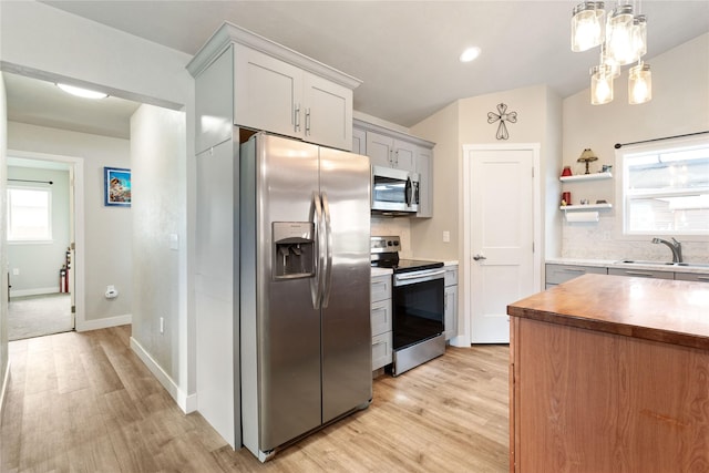 435 6th Ave NW, Ronan, MT 59864 - kitchen with appliances with stainless steel finishes, a sink, backsplash, light wood finished floors, and open shelves