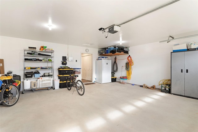 435 6th Ave NW, Ronan, MT 59864 - garage featuring a garage door opener and freestanding refrigerator
