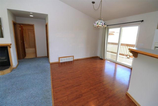 506 Centennial Dr, Sheridan, MT 59749 - empty room featuring wood finished floors, a glass covered fireplace, lofted ceiling, and baseboards