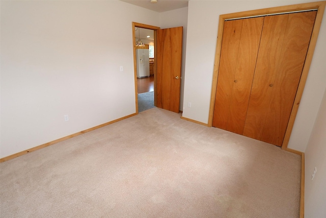 506 Centennial Dr, Sheridan, MT 59749 - unfurnished bedroom with carpet flooring, a closet, white refrigerator with ice dispenser, and baseboards