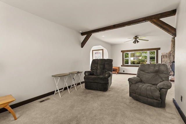 209 Caps Rd, Kalispell, MT 59901 - living room featuring carpet flooring, beamed ceiling, ceiling fan, and a fireplace