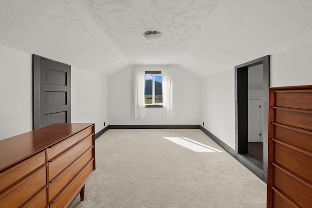 209 Caps Rd, Kalispell, MT 59901 - bonus room featuring vaulted ceiling, light carpet, and a textured ceiling