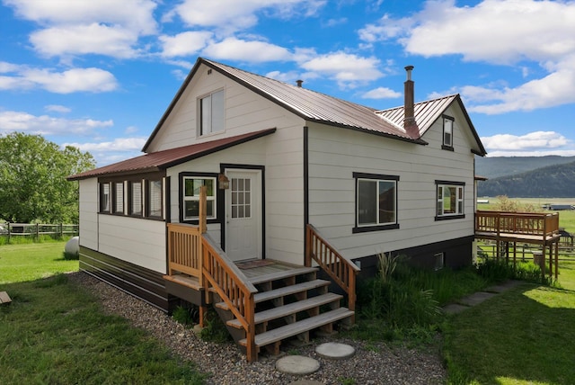 209 Caps Rd, Kalispell, MT 59901 - back of property with a metal roof and a deck with mountain view