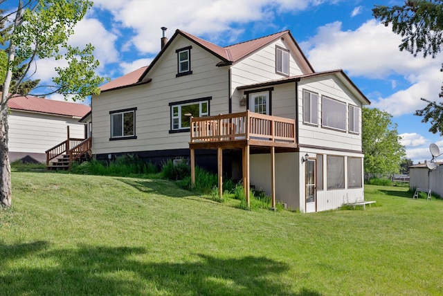 209 Caps Rd, Kalispell, MT 59901 - back of property featuring a lawn, a wooden deck, a metal roof, and a sunroom